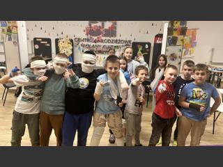 Grupowe zdjęcie dzieci i młodzieży w bandażach po zajęciach.