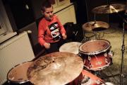 W studiu nagrań na Polanie Kultury chłopiec gra na perkusji.