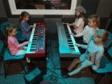 W studiu nagrań na Polanie Kultury dzieci grają na keyboardach.