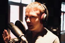 W studiu nagrań chłopak, przed nim mikrofon.