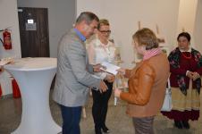 W Ratuszu w Orzyszu Burmistrz Orzysza wręcza nagrodę kobiecie z Koła Gospodyn Wiejskich. Obok Przewodnicząca Rady Miejskiej w Orzyszu. 