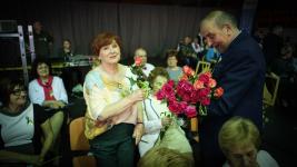 Wicestarosta Marek Wysocki rozdaje kobietom na widowni kwiaty.