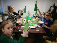 Grupa dzieci prezentuje efekty swojej pracy: choinki tekturowe.