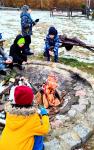 Dzieci zgromadzone przy zimowym ognisku, piekące kiełbaski.