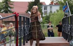Dziewczynka w sukience księżniczki na Moście Zakochanych podczas przedstawienia.
