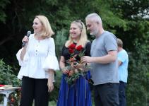 Joanna Kamieniecka z mikrofonem, Ewa Stankiewicz i Krzystof Roszko z różami. 